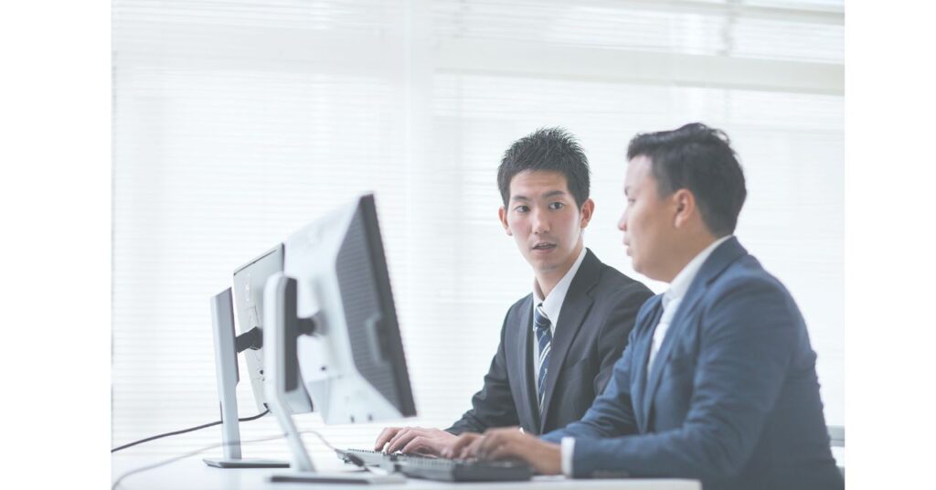 職場で向かい合いながら意見交換するビジネスパーソンたち